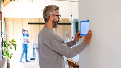 Mann benutzt Smart-Home-Bedienfeld