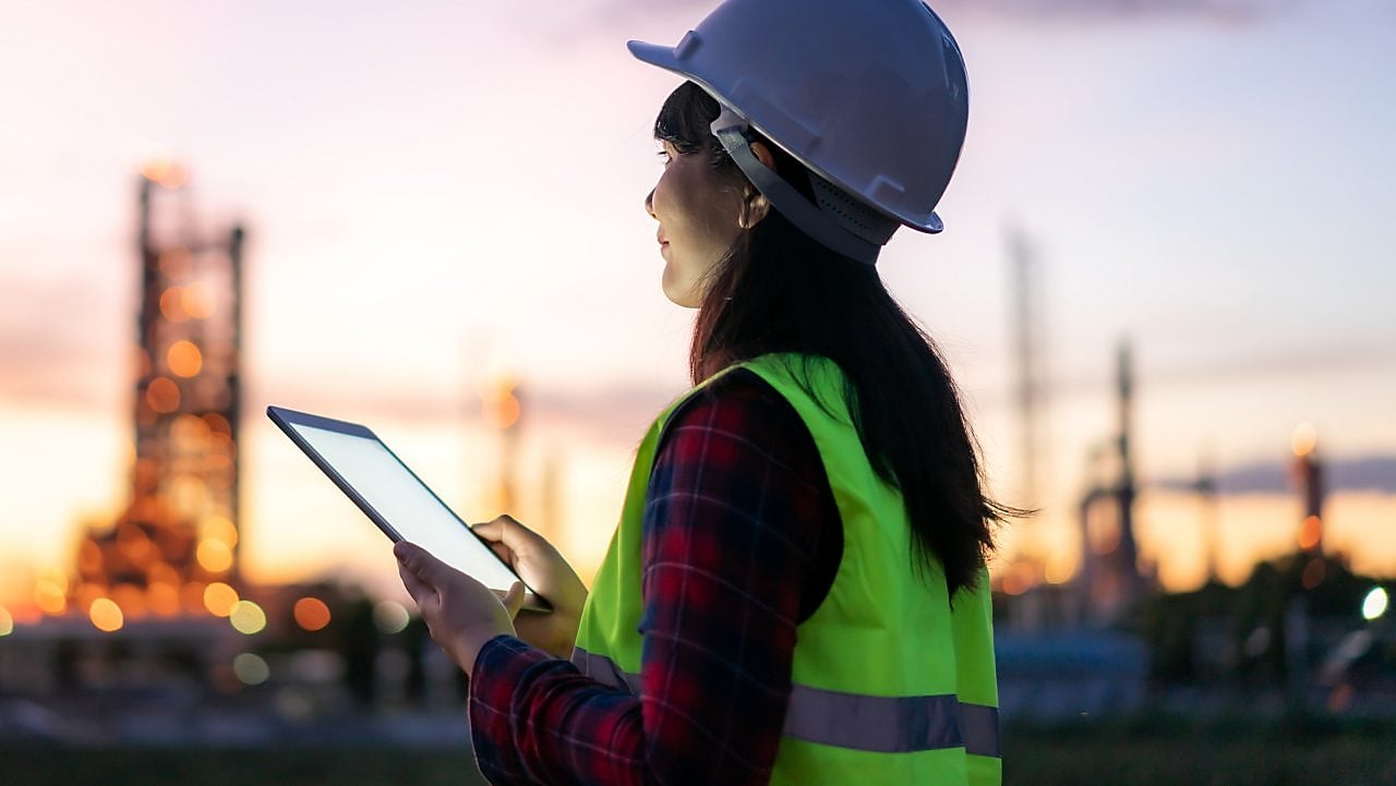 Eine Frau sitzt in einem hellen Raum vor einem Computer.