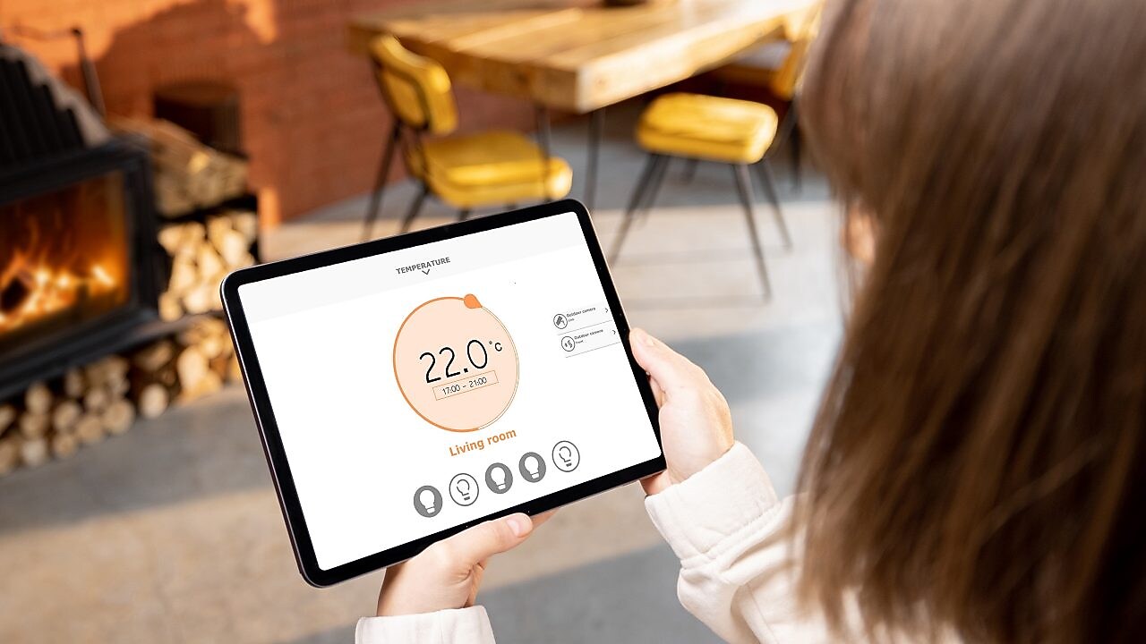 Eine Frau hält ein Tablet mit Smart-Home Funktionen