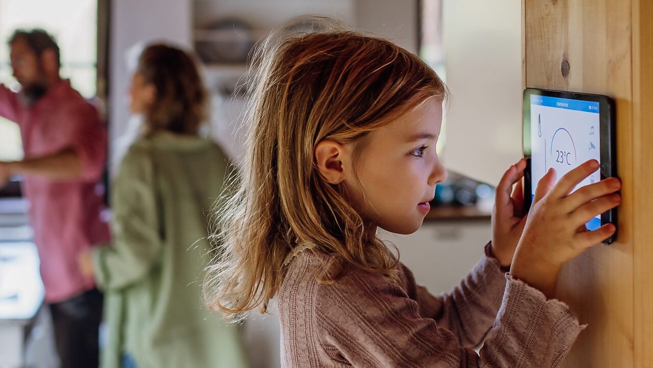 Ein Kind verwendet SmartHome fürs heizen.