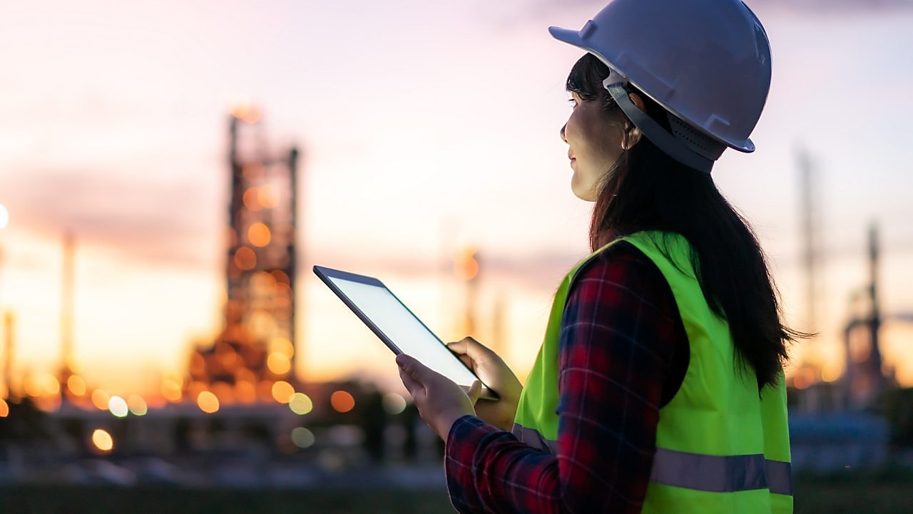 Eine Frau sitzt in einem hellen Raum vor einem Computer.