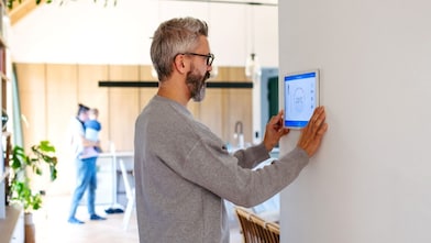 Mann benutzt Smart-Home-Bedienfeld
