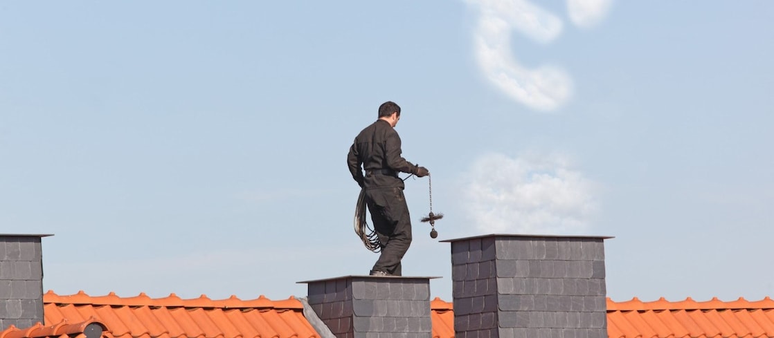 Schornsteinfeger auf dem Dach eines Hauses 