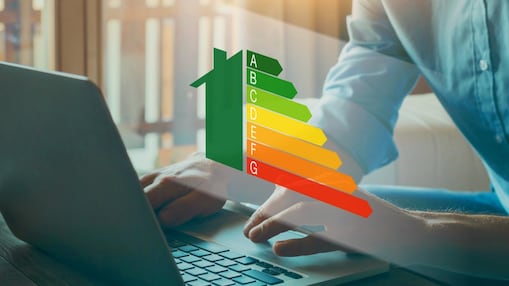 Ein Mensch sitz an einem Laptop und darüber schwebt eine Energieeffizienztabelle