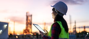 Eine Frau sitzt in einem hellen Raum vor einem Computer.