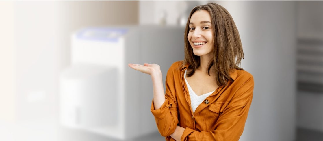 Junge frau lächelt in Kamera und hält ihre Hand flach nach oben gestreckt