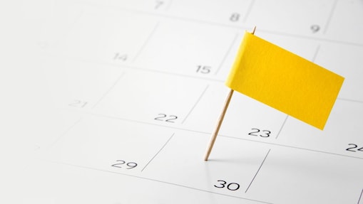 Gelbe Markierungsflagge steckt in einem Kalender auf dem Datum 30