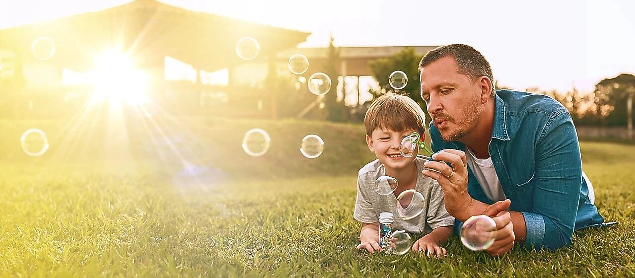 Mann und Kind mit Seifenblasen