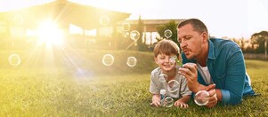 Mann und Kind mit Seifenblasen