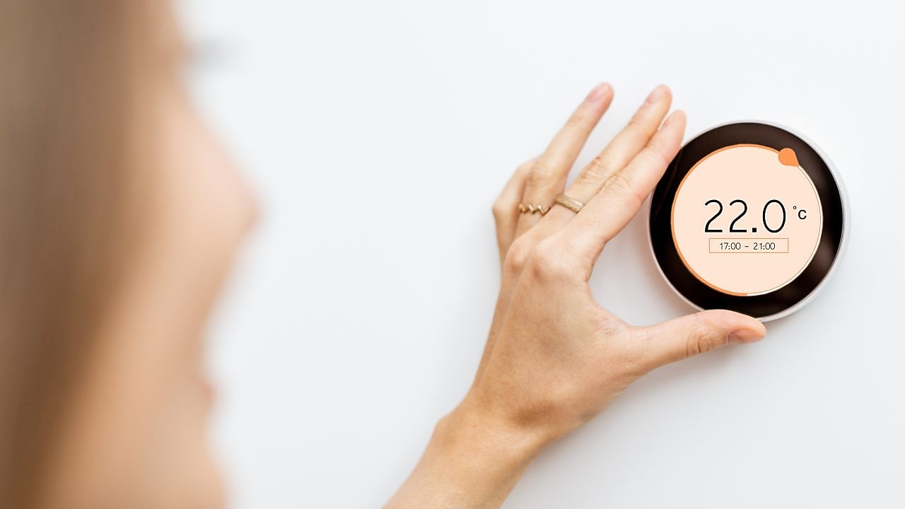 Frau mit digitalem Heizungstermostat