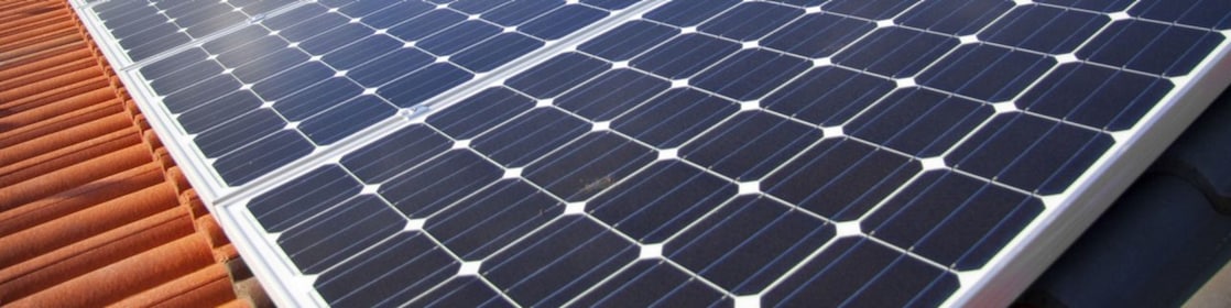 Dach mit Solar Panelen vor blauem Himmel