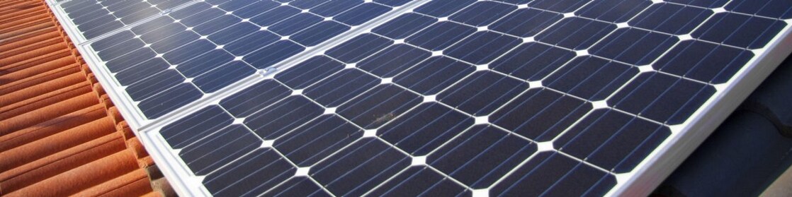 Dach mit Solar Panelen vor blauem Himmel