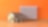 Ein Modellhaus steht vor einer orangefarbenen Wand, an der eine Heizung montiert ist.