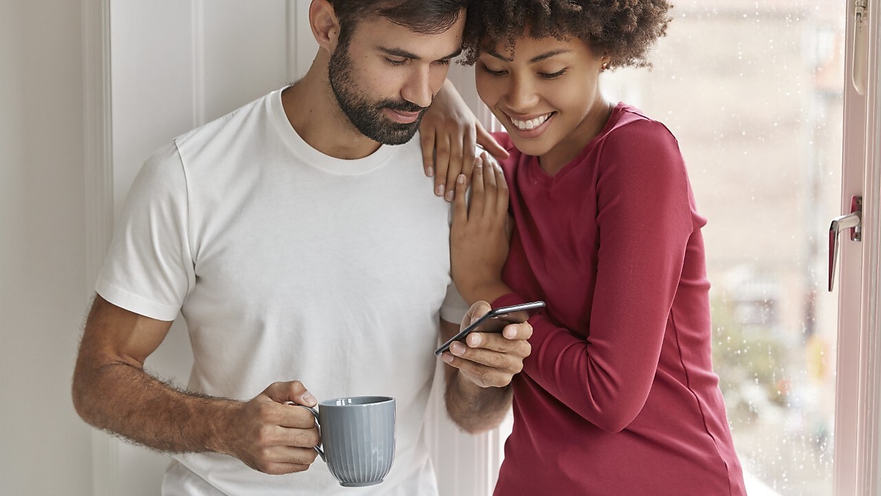 Ein Paar guckt zusammen auf ein Handy.