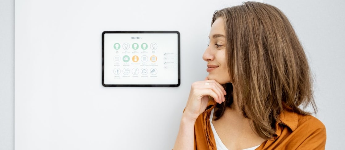 Frau schaut zu Smart Home Bildschirmoberfläche an der Wand