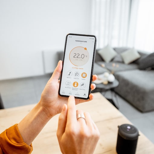 Finger tippt auf Smart Home Bildoberfläche auf dem Smartphone