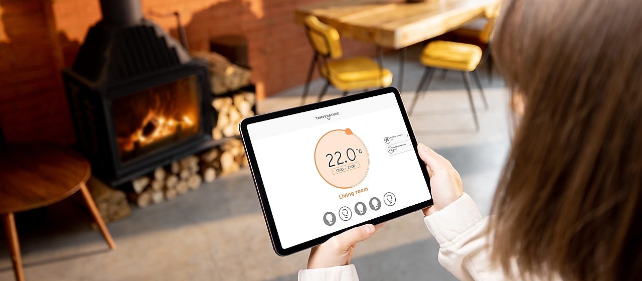Eine Frau hält ein Tablet mit Smart-Home Funktionen