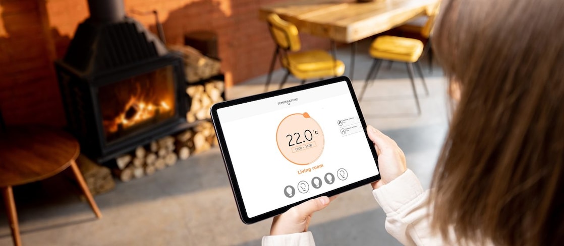 Eine Frau hält ein Tablet mit Smart-Home Funktionen