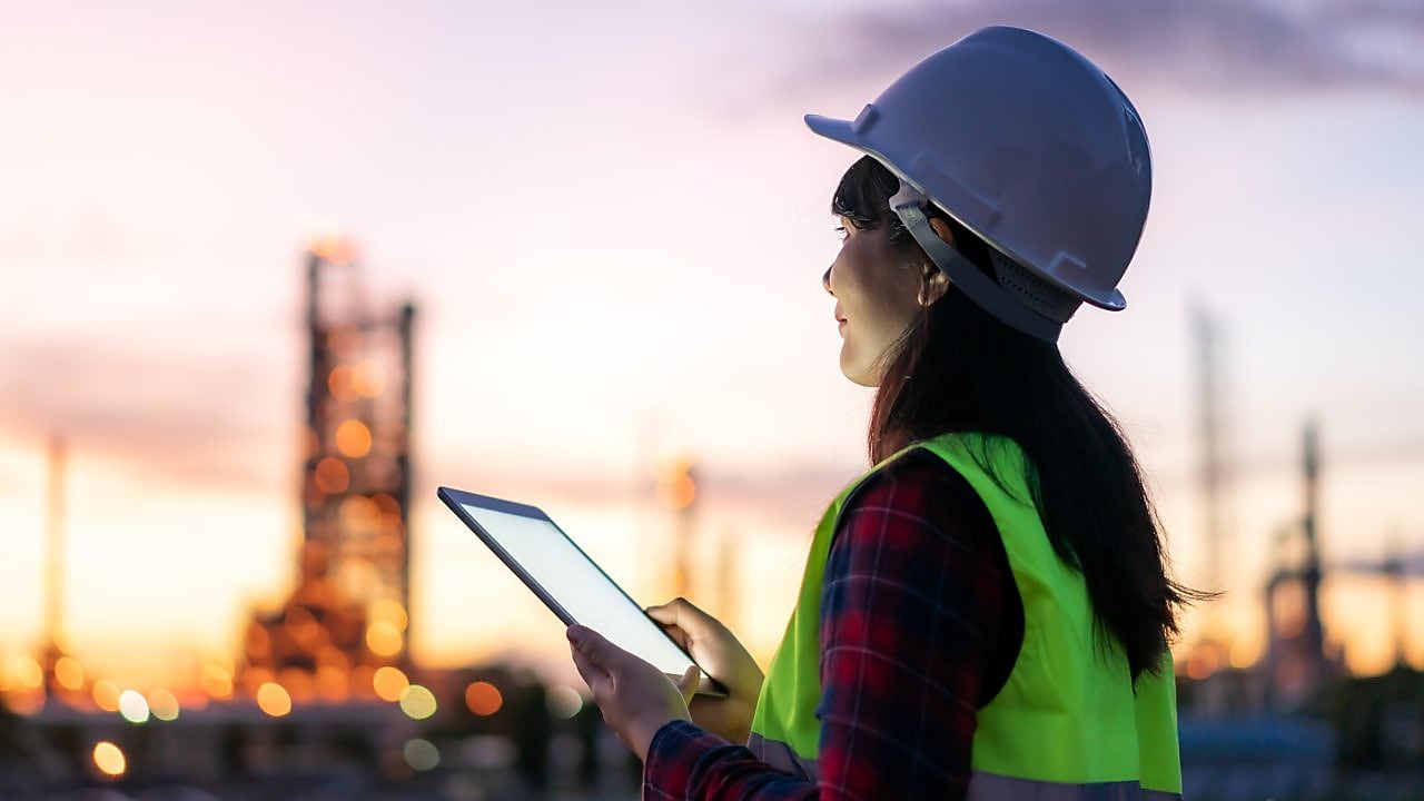 Eine Frau sitzt in einem hellen Raum vor einem Computer.