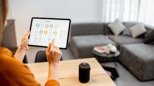 Frau steuert ihr Zuhause über ein digitales Touchscreen-Bedienfeld