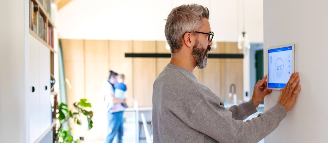 Mann benutzt Smart-Home-Bedienfeld