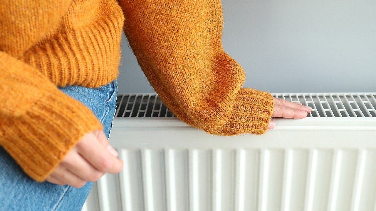 Eine Frau sitzt auf einem Heizkörper