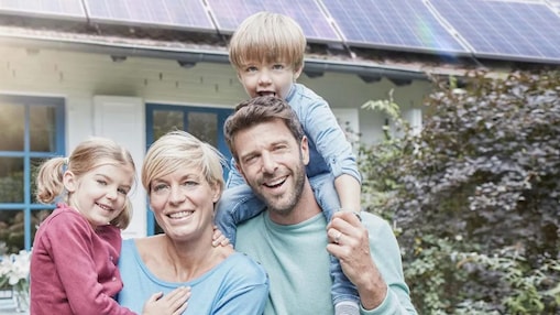 Eine Familie vor einem Haus mit Photovoltaik