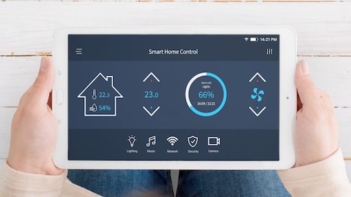 Eine Frau hält ein Tablet in der Hand mit der Anzeige Smart Home Control