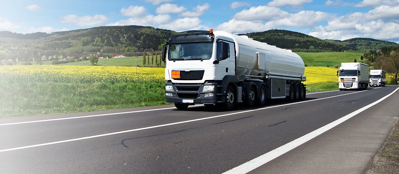 Ein Tanklaster auf einer Bundesstraße von gelben Rapsfeldern umgeben