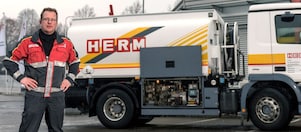 Herm GmbH Tankwagenfahrer steht neben Tankwagen